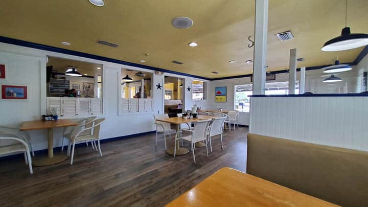 Beach Diner at Atlantic Beach inside dining area showing yellow and blue trim with white walls, tables, and chairs with bright interior.